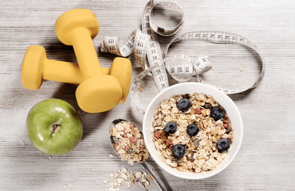 weights, tape measure, whole grain foods on a table for weight loss journey