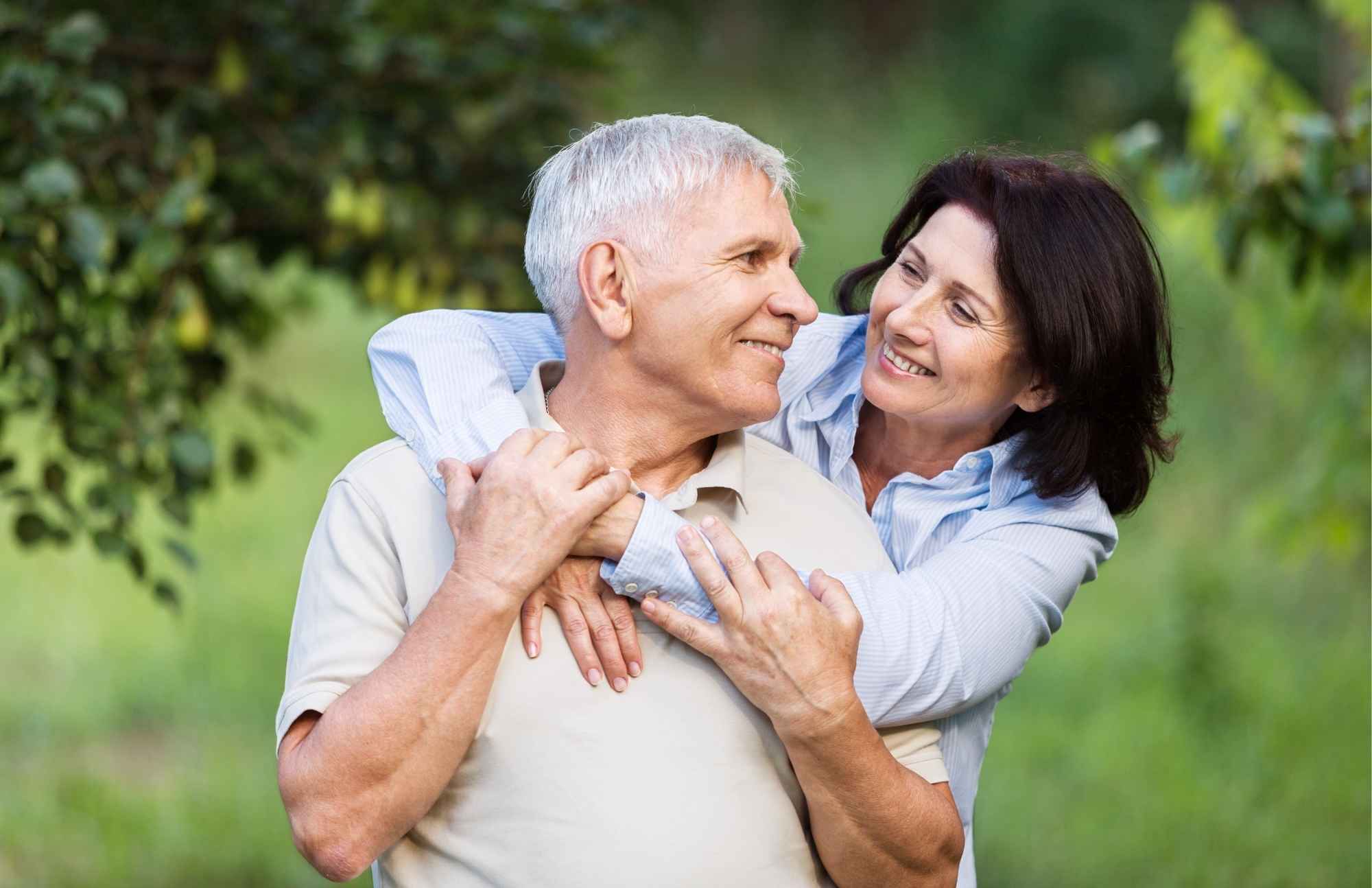 An older couple embracing outdoors, symbolizing long-term health monitoring and proactive disease prevention.