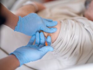 A doctor injecting a patient for pain relief