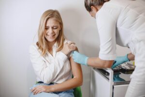 A doctor injecting a patient in her arm.