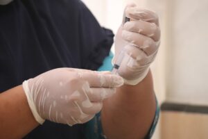 A doctor filling up a syringe for pain relief dose