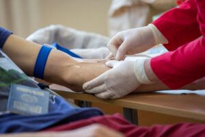 A nurse injecting an IV drip to a patients arm