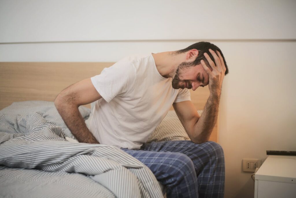 A man sitting in bed with a very severe pain