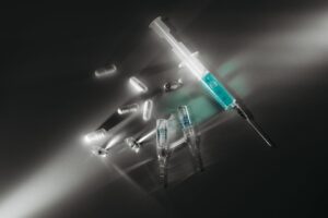 tablets, medicines, and injections laying on a table.